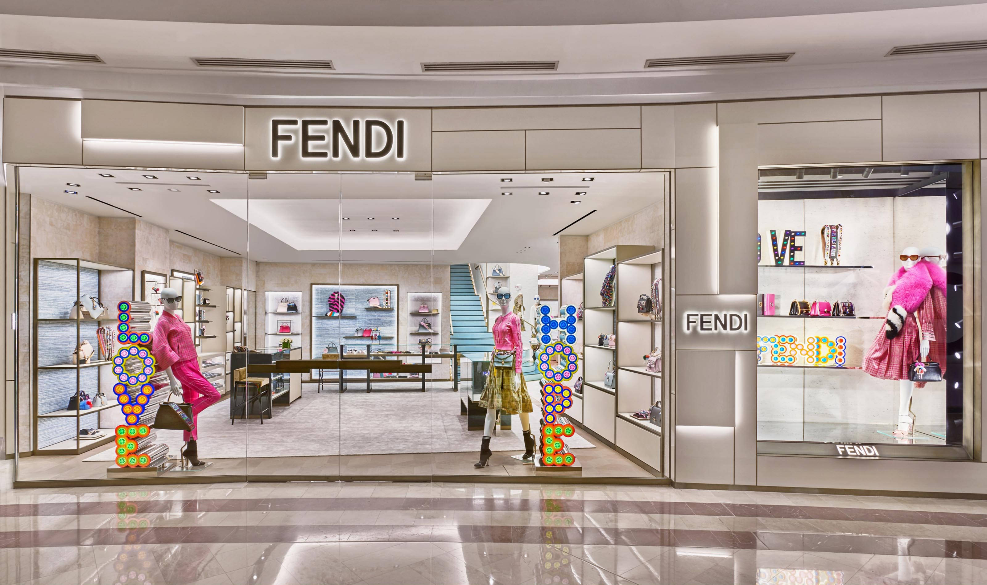 Fendi 桌布 壁紙 — Fendi 旗艦店，展示身穿粉紅色服裝的人體模型和色彩繽紛的泡泡展示，在明亮的室內燈光下。