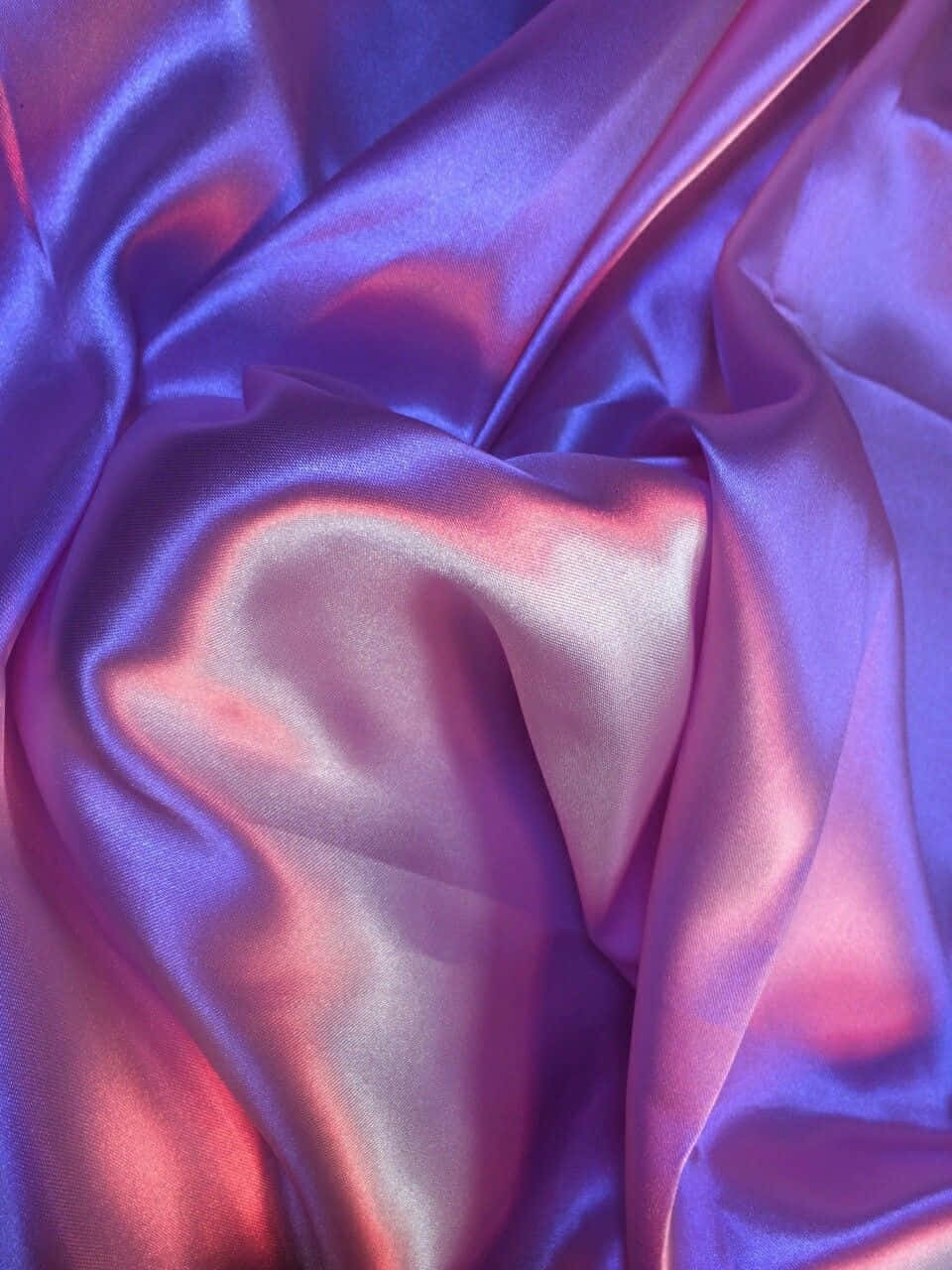 Purple Silk 桌布 壁紙 — 豐富的紫色和粉紅色緞面布料，帶有光澤的褶皺，捕捉柔和光線，呈現奢華質感。