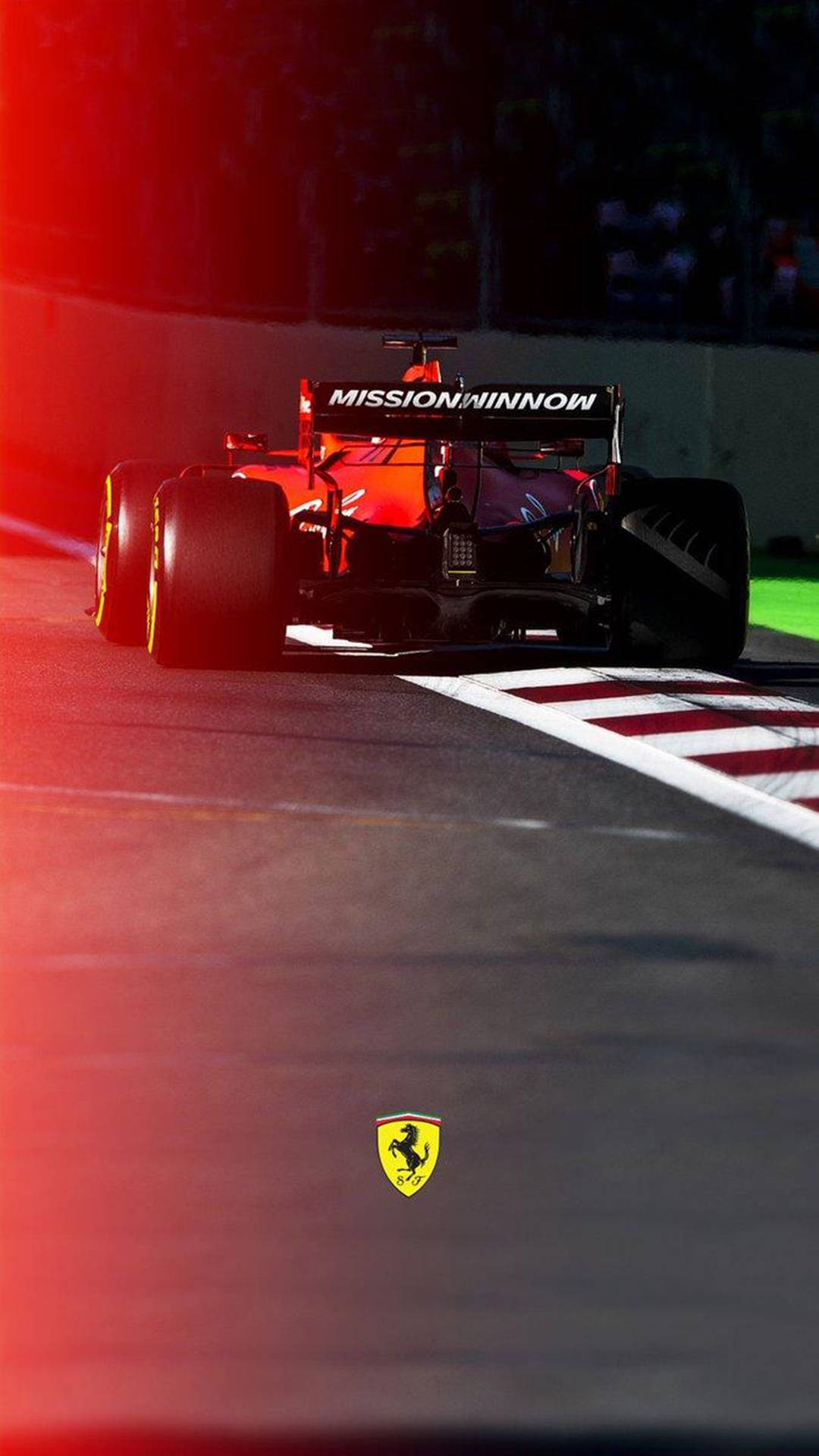 法拉利F1賽車在夜間賽道上奔馳，伴隨紅色燈光。 — F1 壁紙