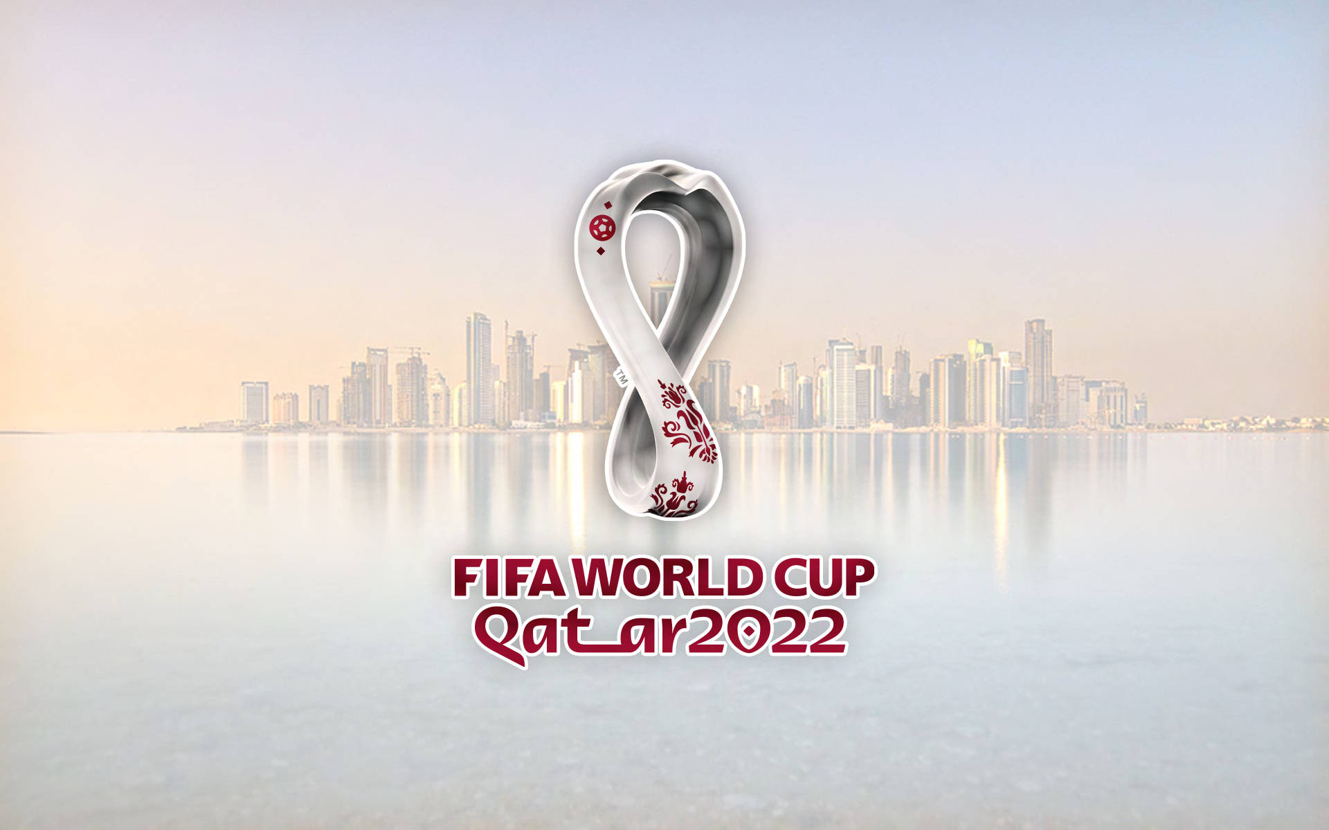 World 桌布 壁紙 — FIFA世界盃卡達2022標誌在黎明時分漂浮在寧靜的海濱城市景觀上。