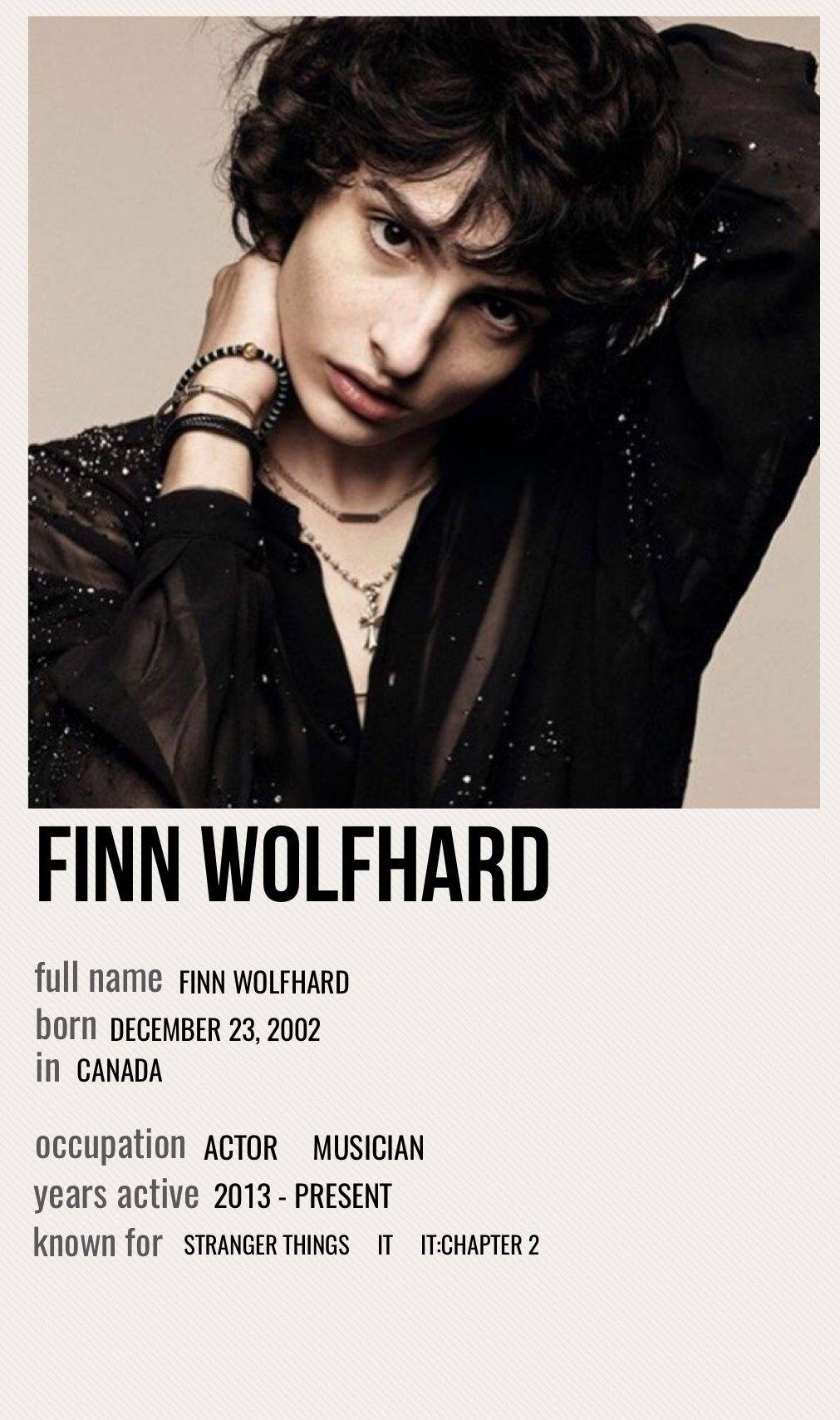 finn wolfhard 桌布 壁紙 — Finn Wolfhard 的 close-up 肖像，深色捲髮，穿著黑色閃亮衣服和層疊項鍊，背景中性。