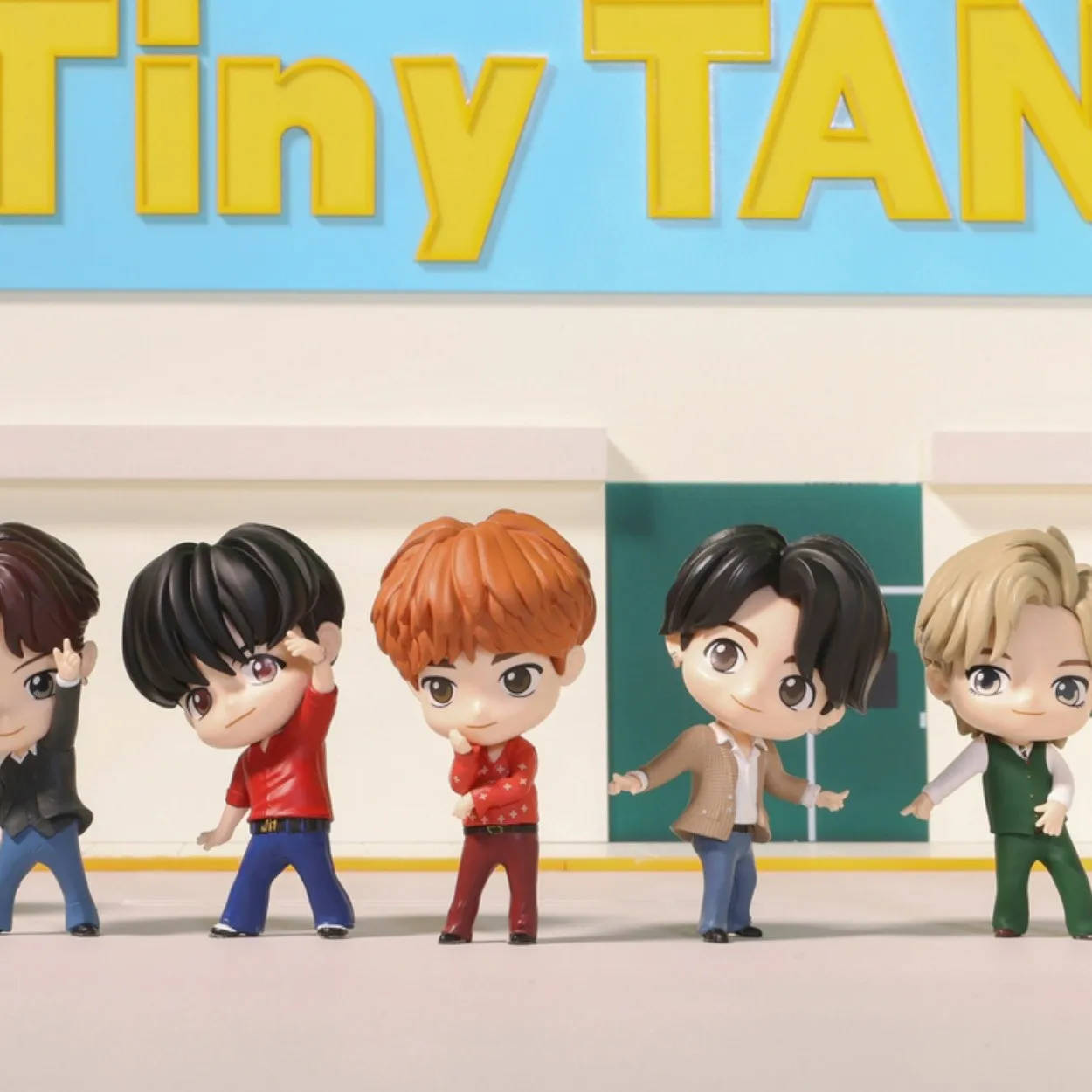 五個Q版BTS公仔在'Tiny TAN'招牌前面擺姿勢。 — Bts 壁紙