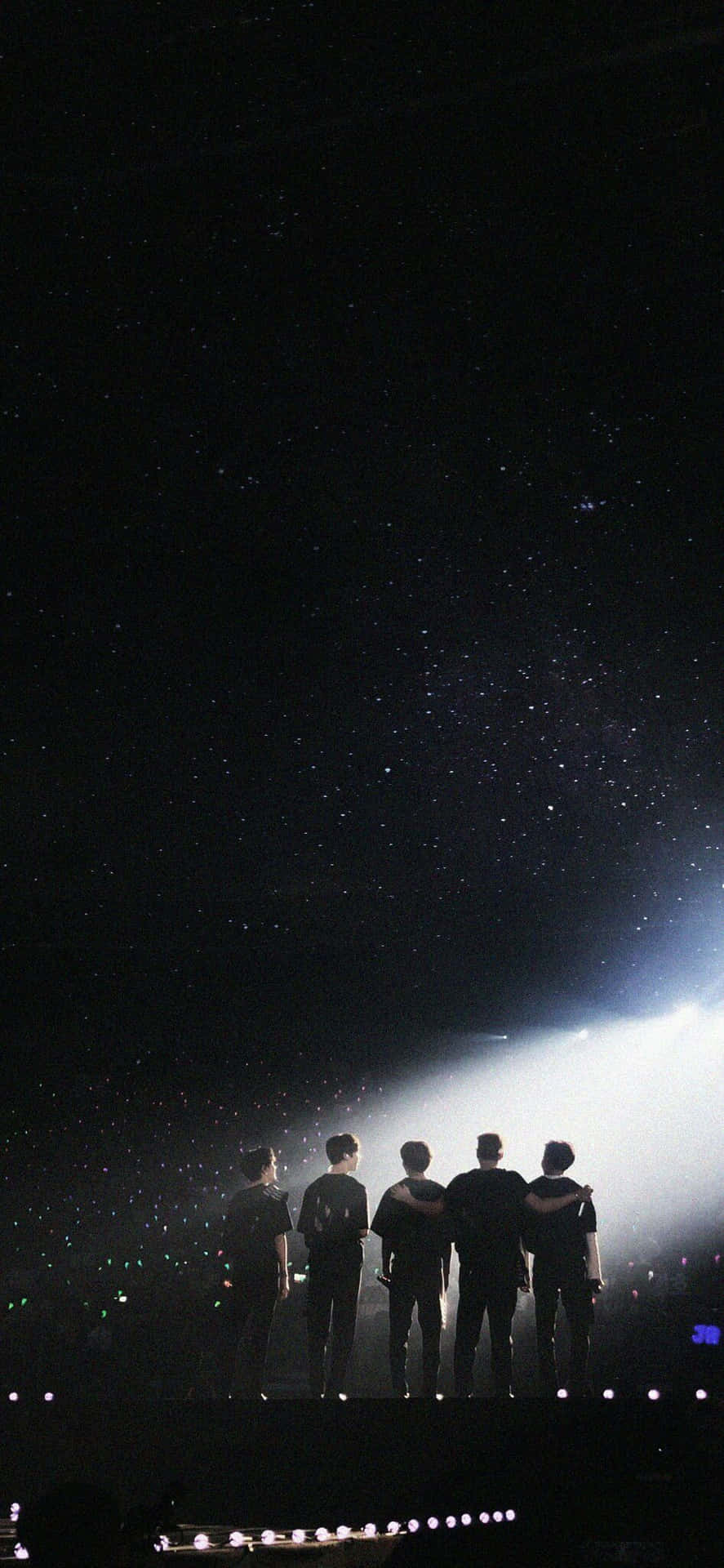 五個人在舞台上，以星光燦爛的夜空為背景，形成剪影，並有聚光燈照射。 — K Pop 壁紙
