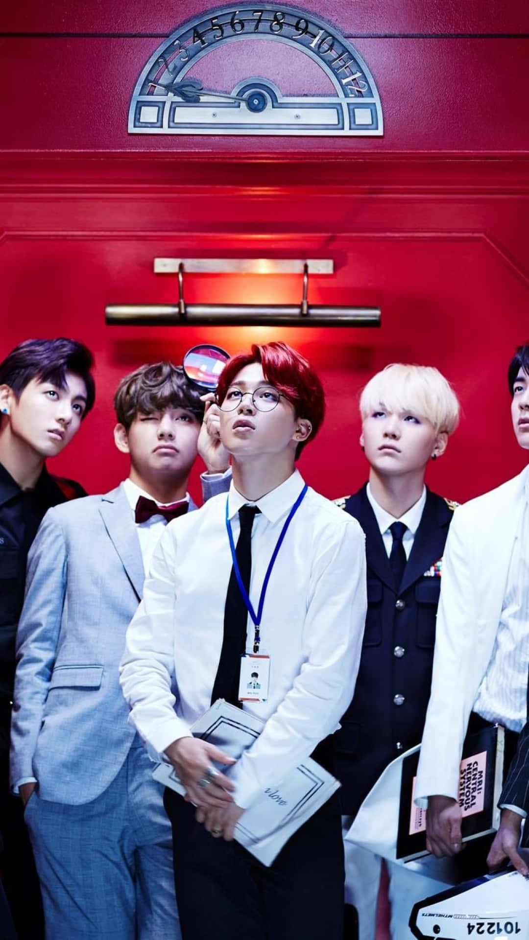五位穿著西裝的時尚男子在紅色牆壁前擺姿勢，牆上有一個時鐘。 — Bts 壁紙