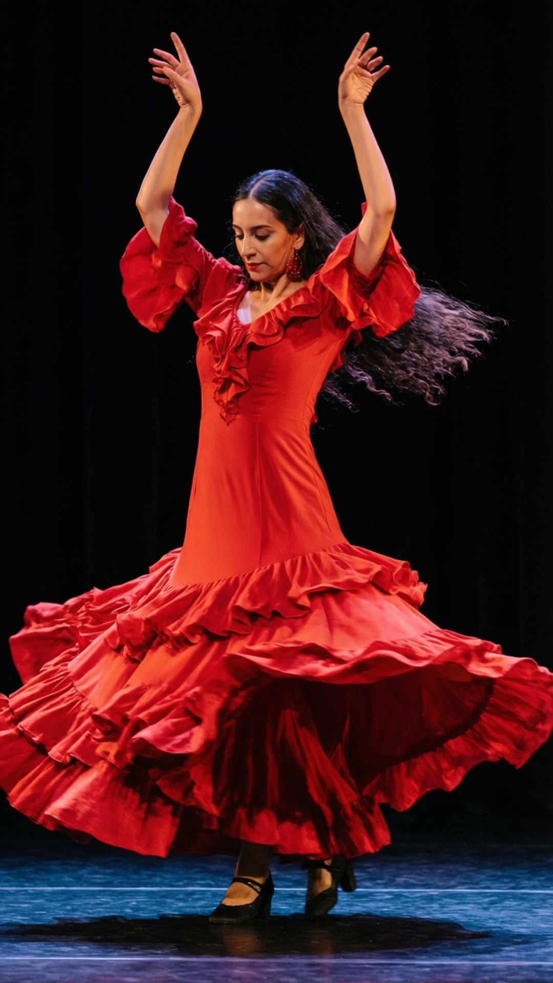 Flamenco Passion Spiral 壁紙 — 一位身穿鮮紅色荷葉邊裙的佛朗明哥舞者在黑暗的舞台上優雅地旋轉，雙臂高舉，秀髮飄逸。