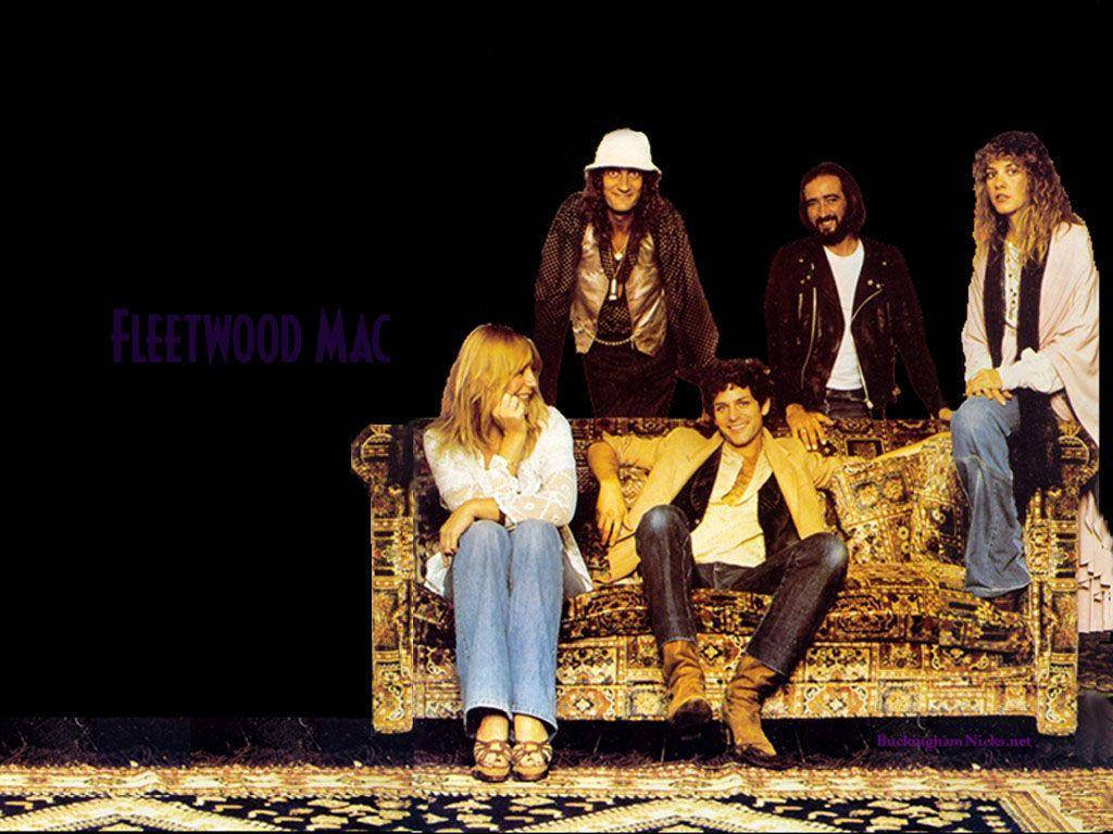 band 桌布 壁紙 — Fleetwood Mac 樂團成員在黑色背景上帶有紫色文字的華麗金色沙發上擺姿勢。