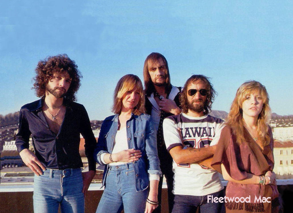 復古 桌布 壁紙 — Fleetwood Mac 樂團成員在屋頂上自信地擺姿勢，背景是晴朗的藍天和城市景觀。