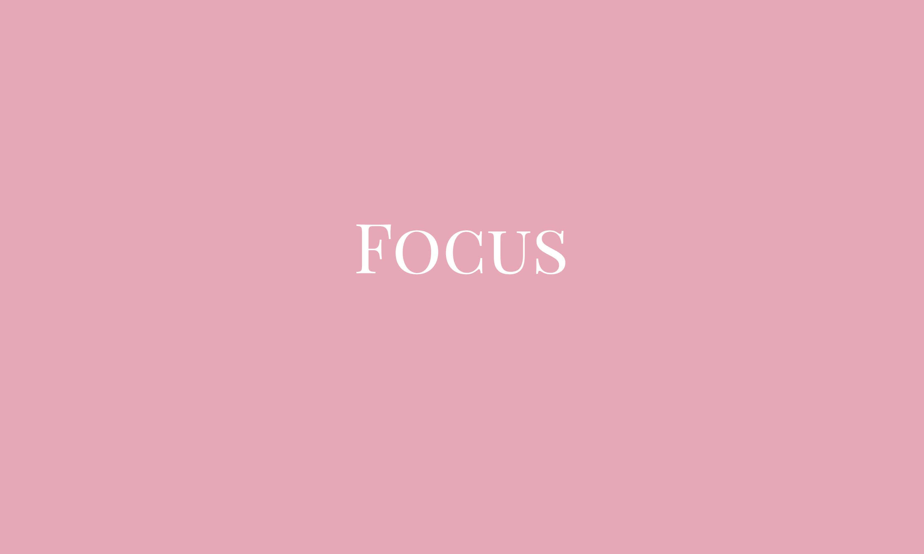 美學粉色GIF 桌布 壁紙 — 「focus」一詞以優雅的白色襯線字體居中顯示在柔和的粉紅色背景上。