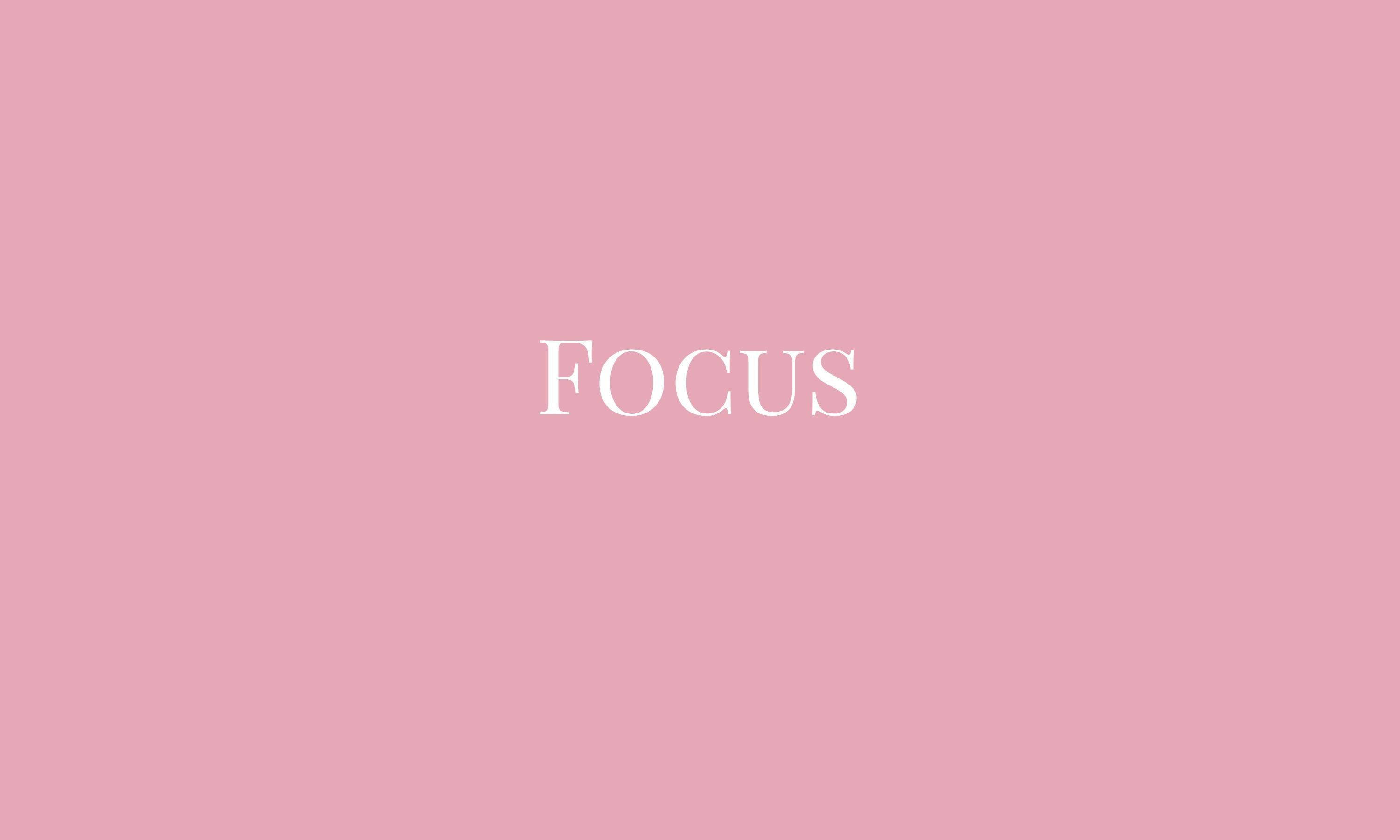 粉紅色 桌布 壁紙 — 「focus」一詞以優雅的白色襯線字體居中顯示在柔和的粉紅色背景上。