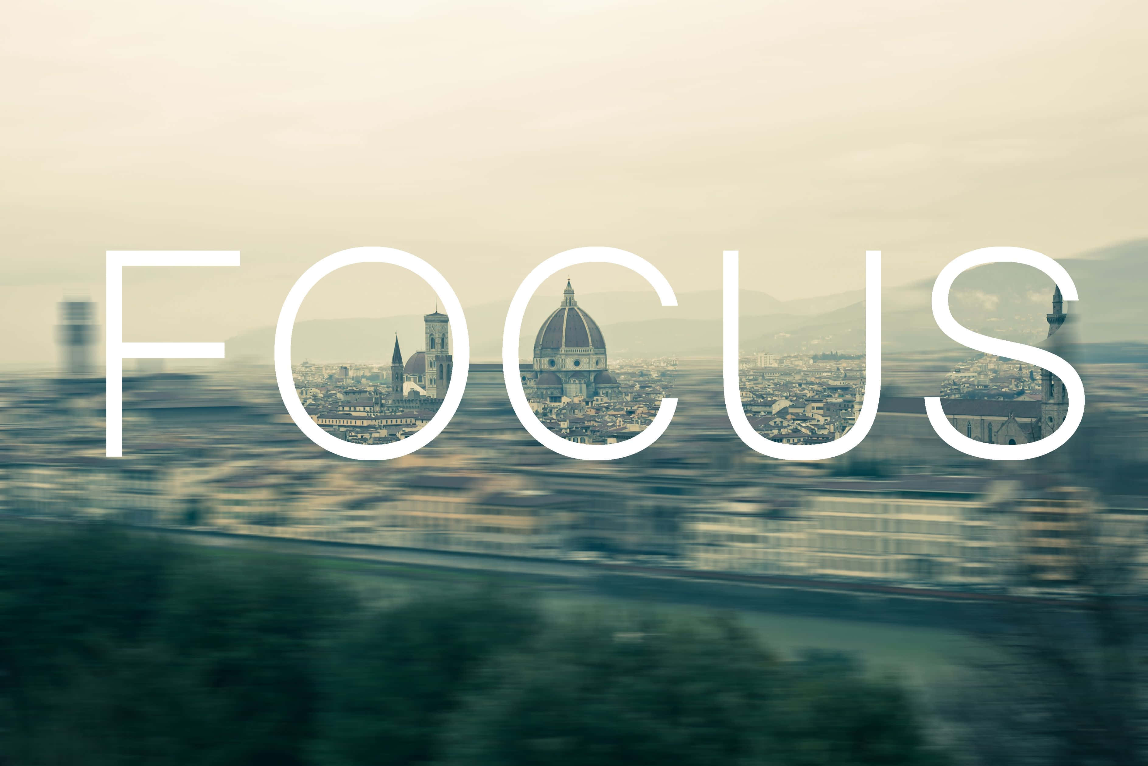 Focus 桌布 壁紙 — 「focus」這個字疊加在模糊的城市景觀上，佛羅倫斯的圓頂透過字母可見。