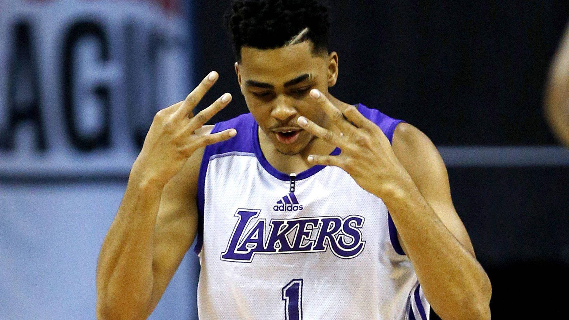 身穿湖人隊球衣的籃球運動員在比賽中做手勢。 — NBA 壁紙
