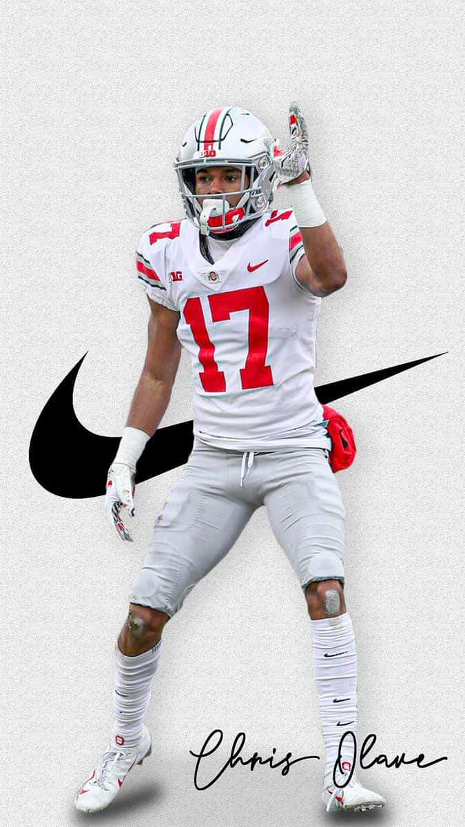  壁紙 — 美式足球員Chris Olave身穿白色俄亥俄州立大學17號球衣，在帶有Nike標誌的紋理灰色背景上舉手慶祝。