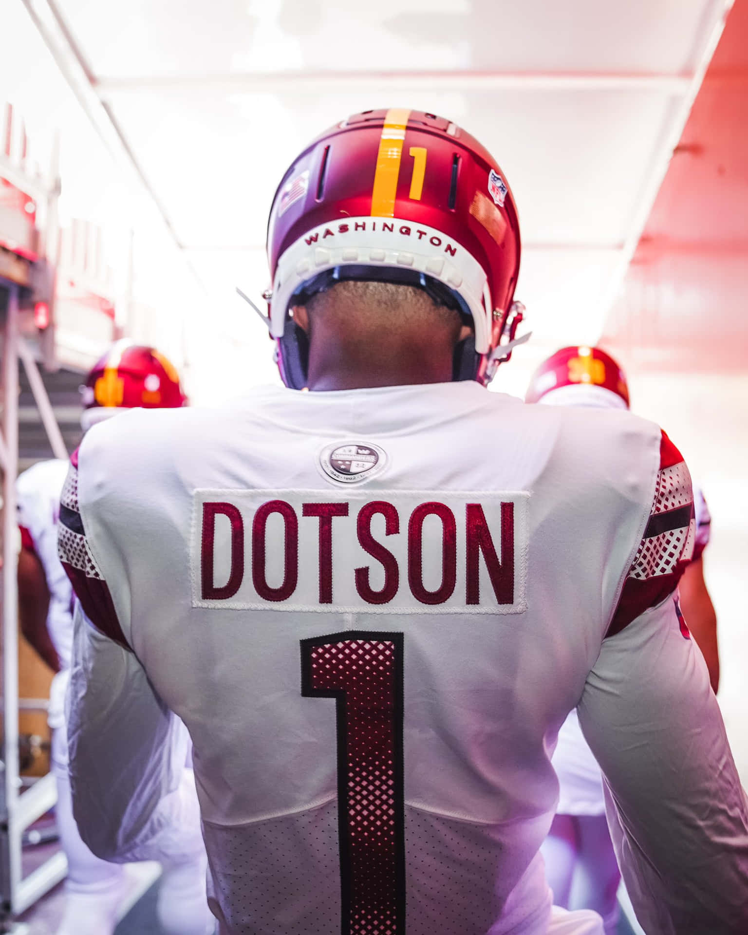  壁紙 — 一名身穿白色球衣、印有「DOTSON」和號碼「1」的足球運動員，沿著燈光明亮的隧道走向球場。