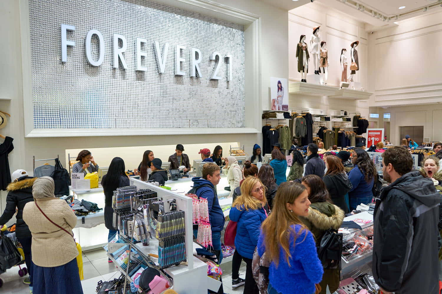 永遠21 桌布 壁紙 — Forever 21 店內人潮擁擠，顧客在明亮的螢光燈下瀏覽貨架和結帳櫃檯。