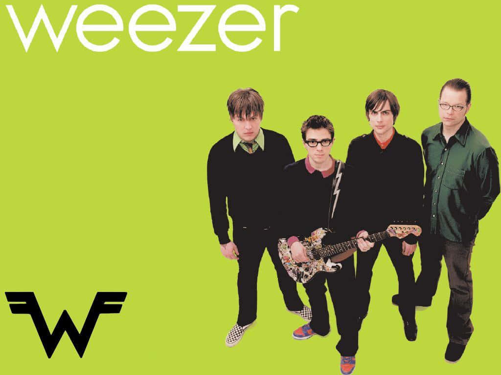  壁紙 — 四位樂團成員站在明亮的萊姆綠色背景前，並突出顯示「Weezer」字樣和標誌。