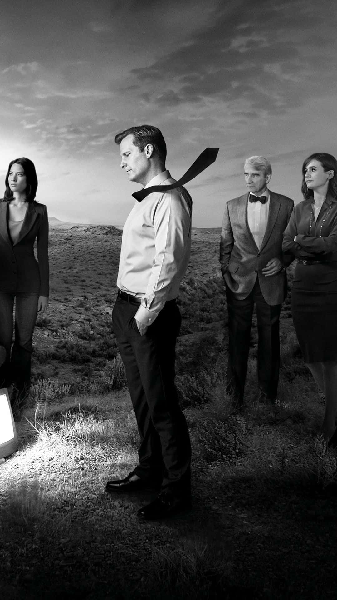 Tv Series 桌布 壁紙 — 四個穿著正式的人站在陰天下一片荒涼的沙漠景觀中，其中一個男人的領帶戲劇性地向上飛揚。