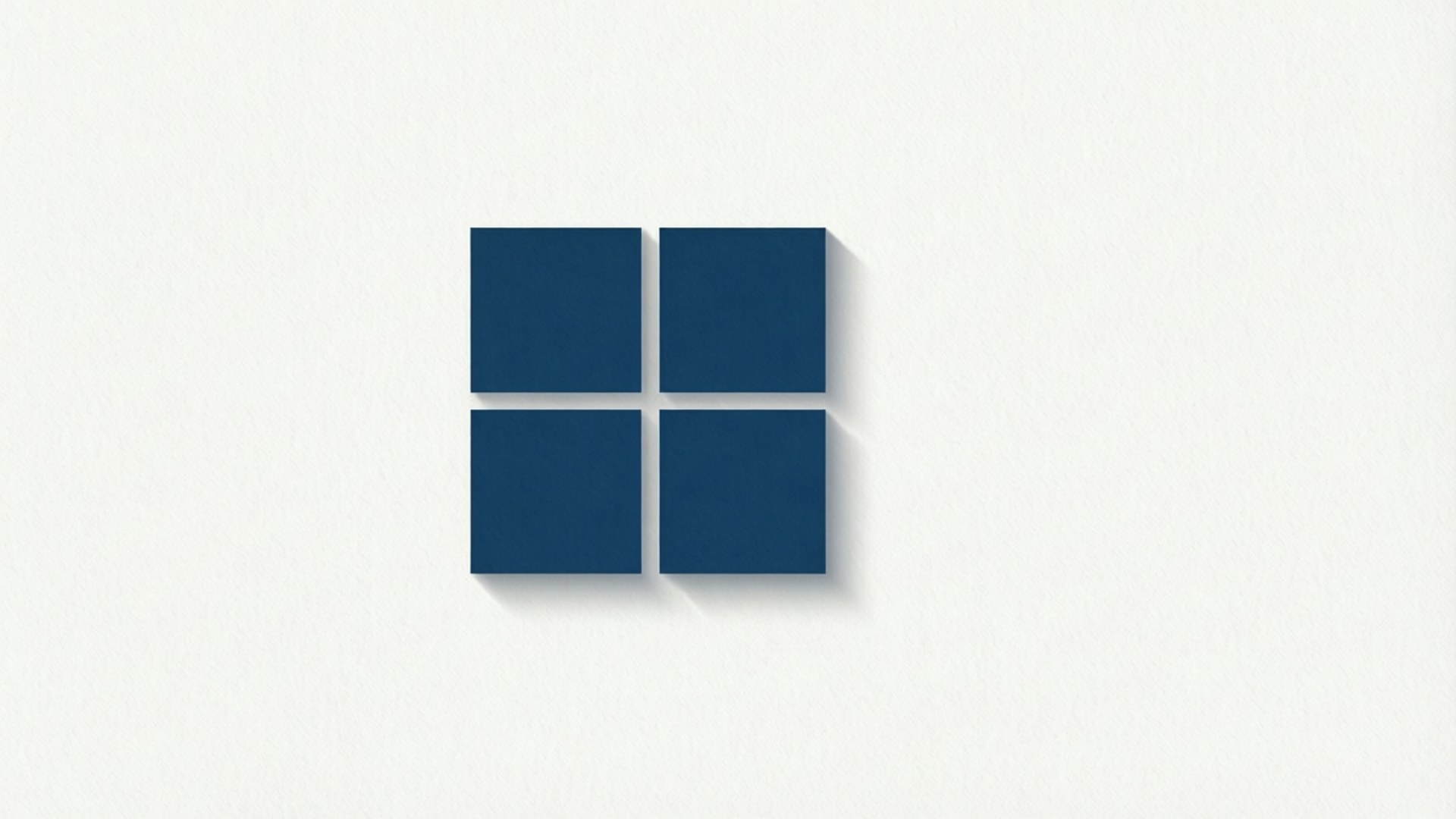 Minimalist Microsoft Logo 壁紙 — 四個海軍藍色正方形排列成窗戶標誌，在紋理白色牆壁上帶有柔和陰影。
