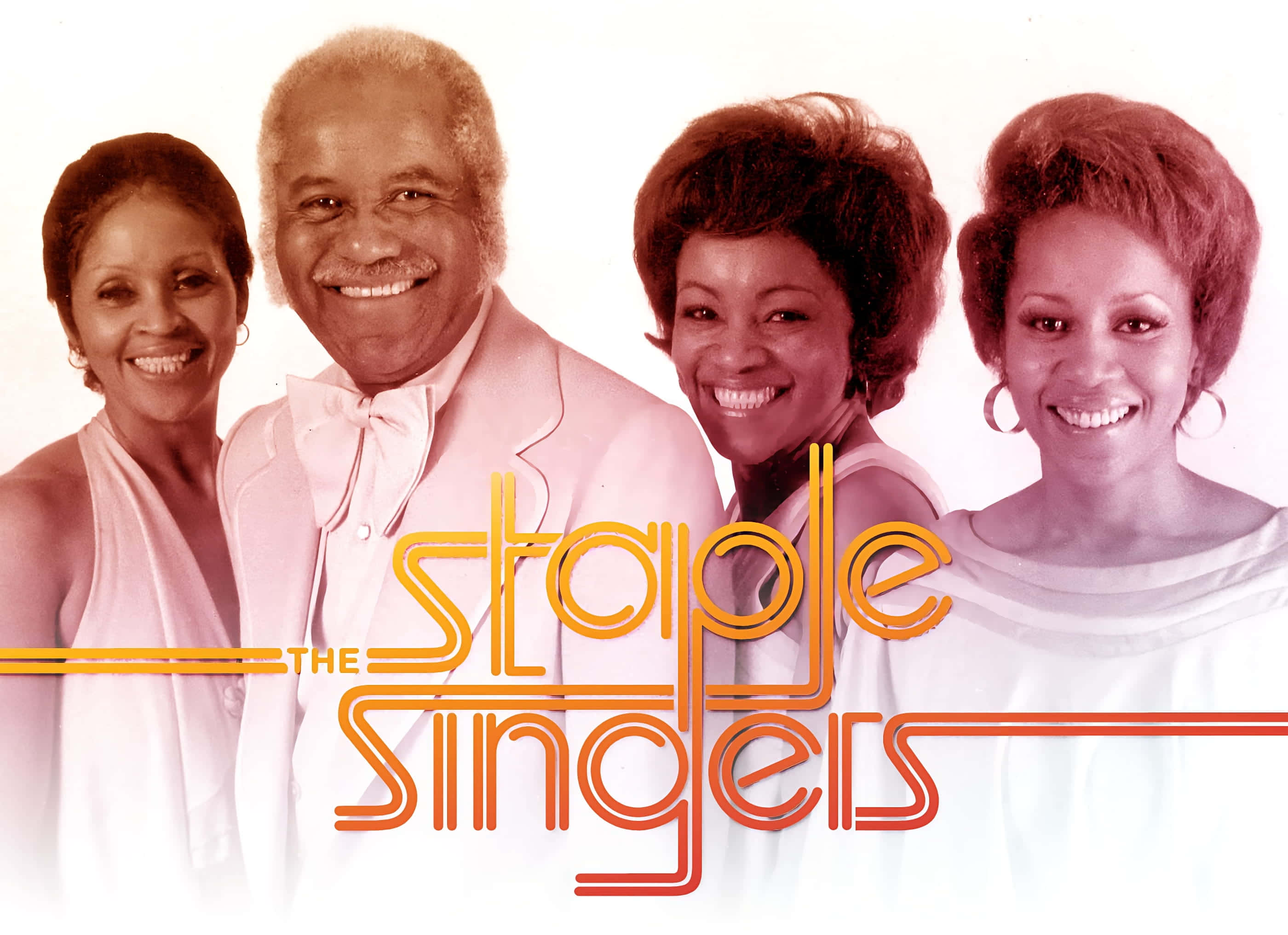 American 桌布 壁紙 — The Staple Singers 的四位微笑成員穿著復古粉紅和白色服裝，在純色背景前擺姿勢，並帶有風格化的橙色文字。