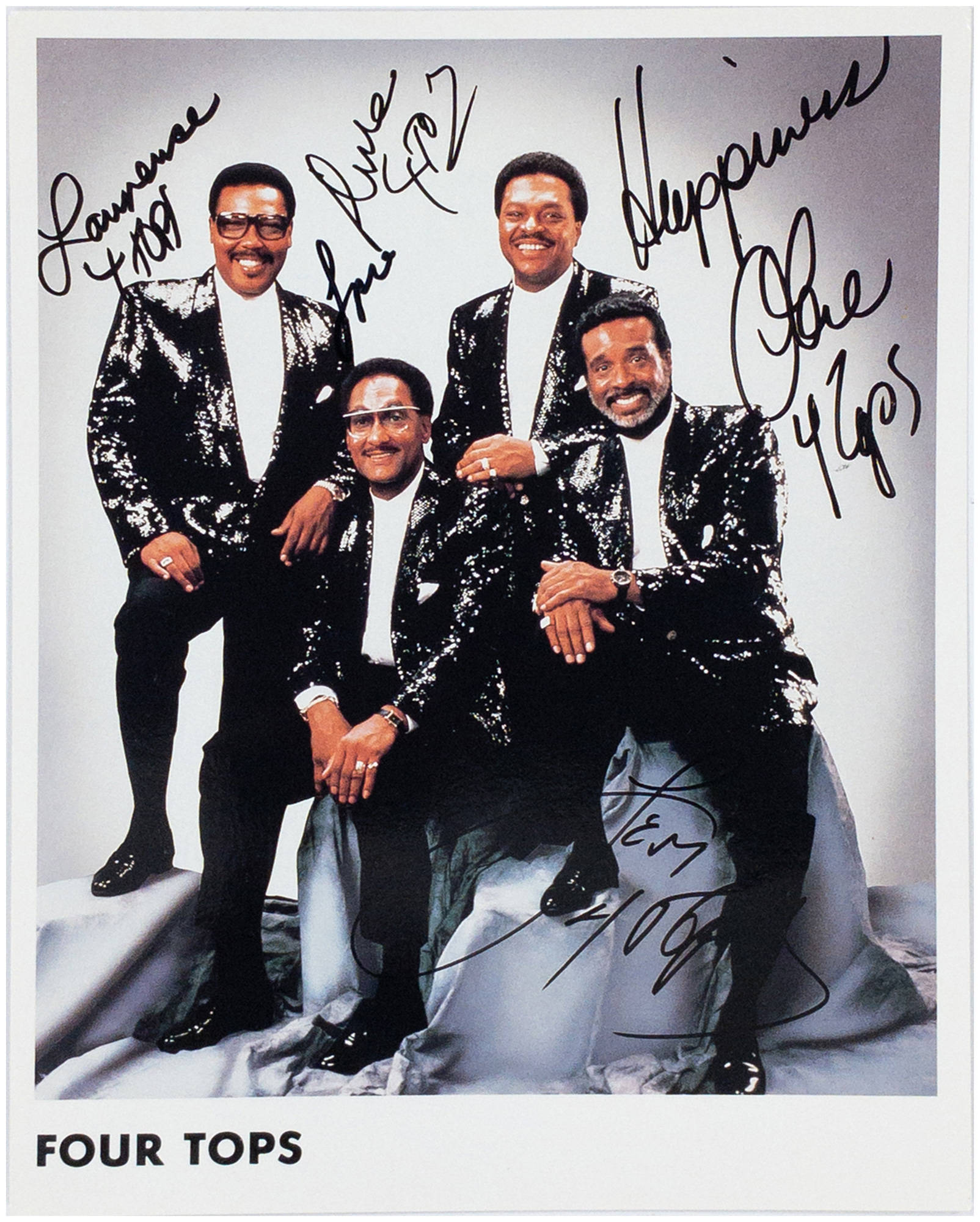 Famous 桌布 壁紙 — Four Tops 身穿閃亮黑色外套，自信地擺姿勢在帶有褶皺的銀色佈景上，下方有手寫簽名和「Four Tops」文字。