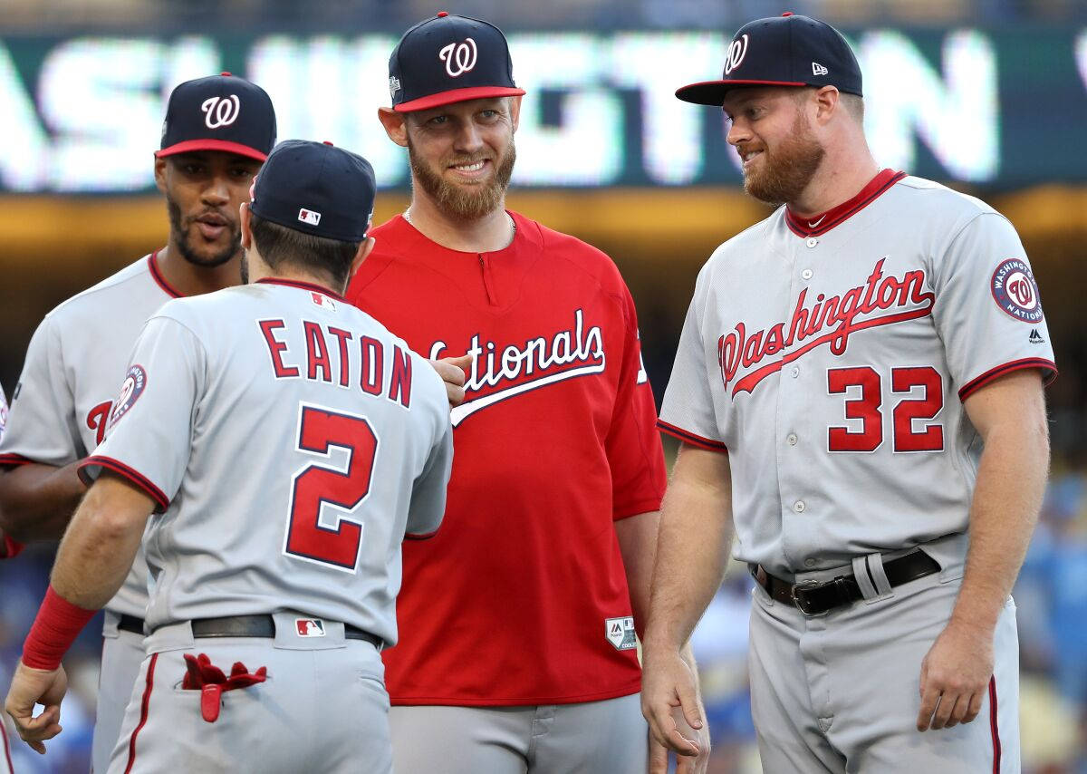 四名身穿球衣的華盛頓國民隊棒球選手在陽光明媚的球場上。 — MLB 壁紙