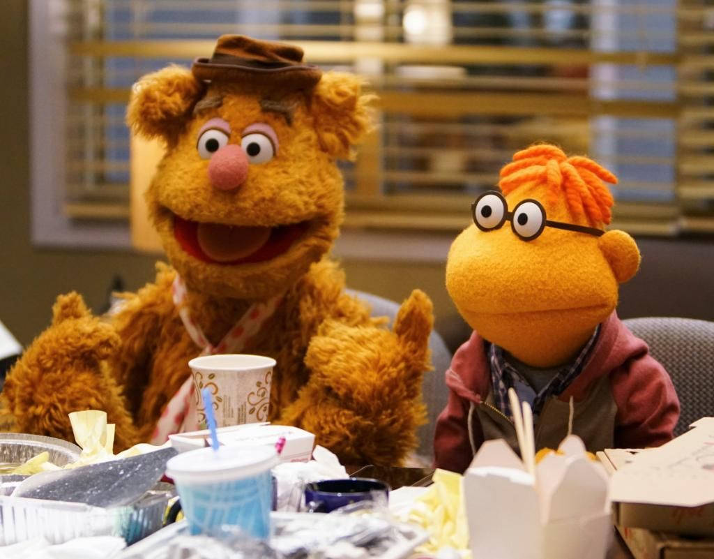 Fozzie Bear 桌布 壁紙 — Fozzie Bear 和一個戴眼鏡的橙色木偶坐在一張凌亂的桌子旁，桌上擺滿了外賣食物和飲料。