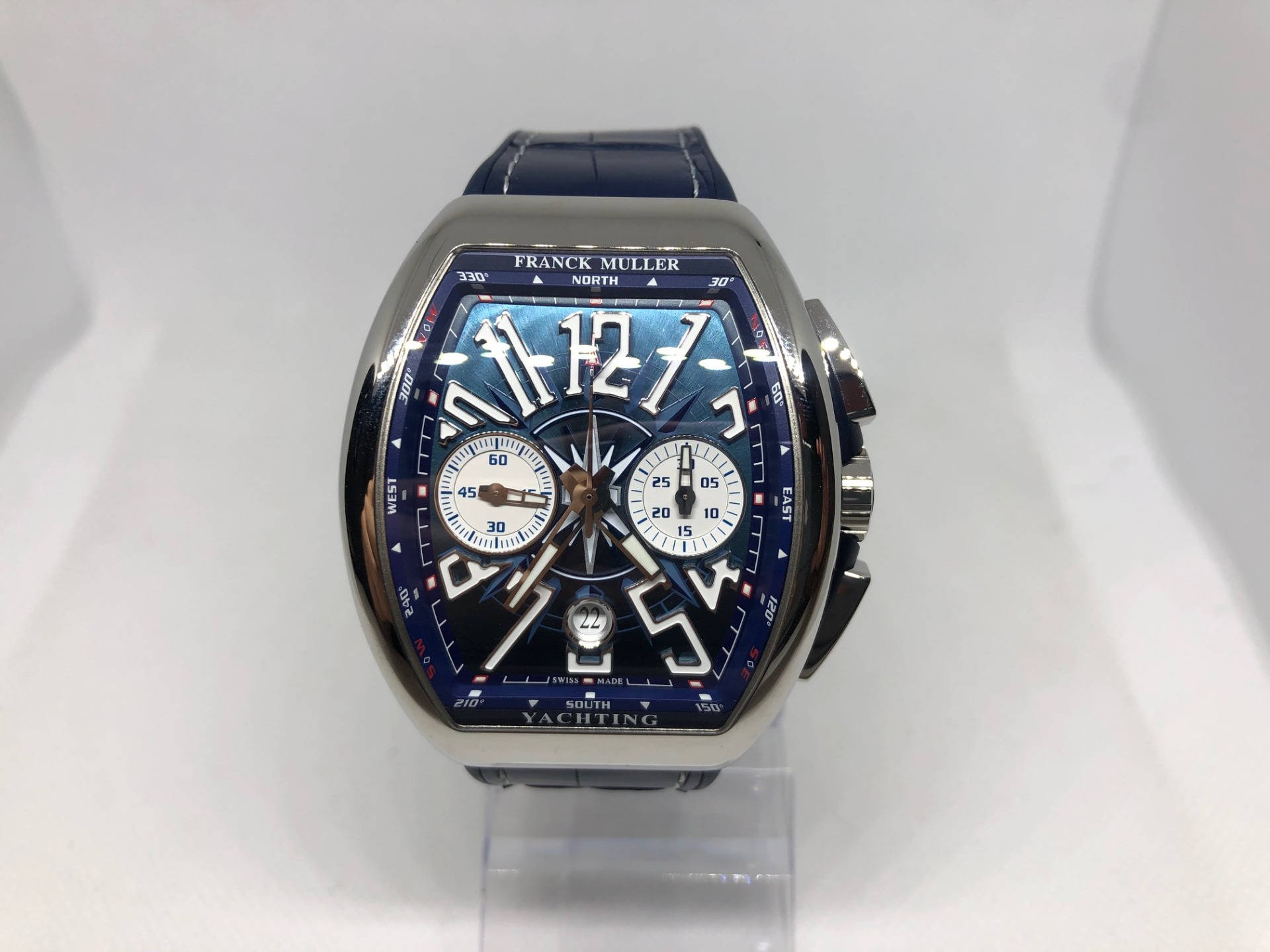 藍色 桌布 壁紙 — Franck Muller Yachting 手錶，藍色指南針錶盤設計，配皮革錶帶，展示在透明支架上。