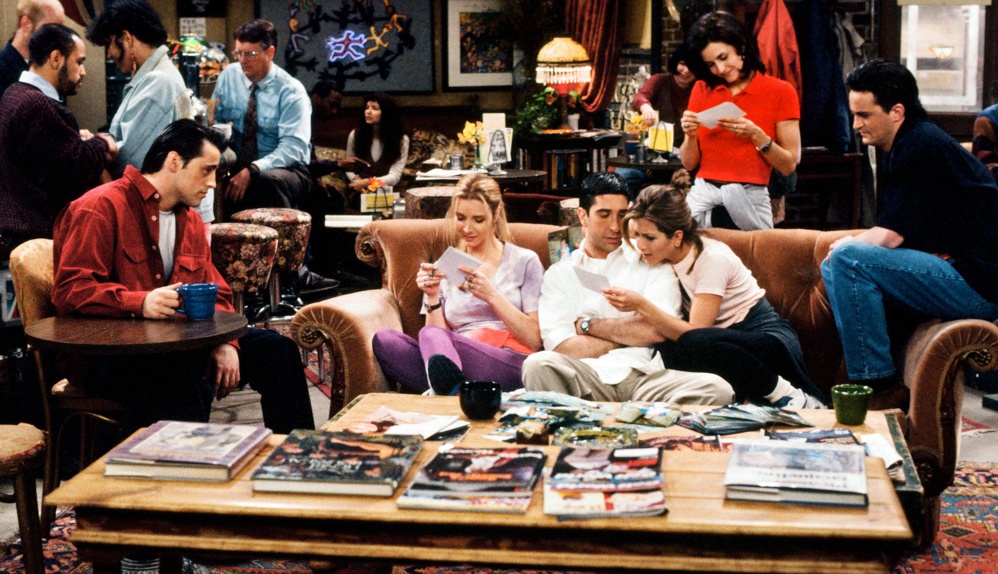 Friends 桌布 壁紙 — Friends 情境喜劇演員在標誌性的公寓客廳中休息，周圍是雜亂的咖啡桌和溫暖的裝飾。