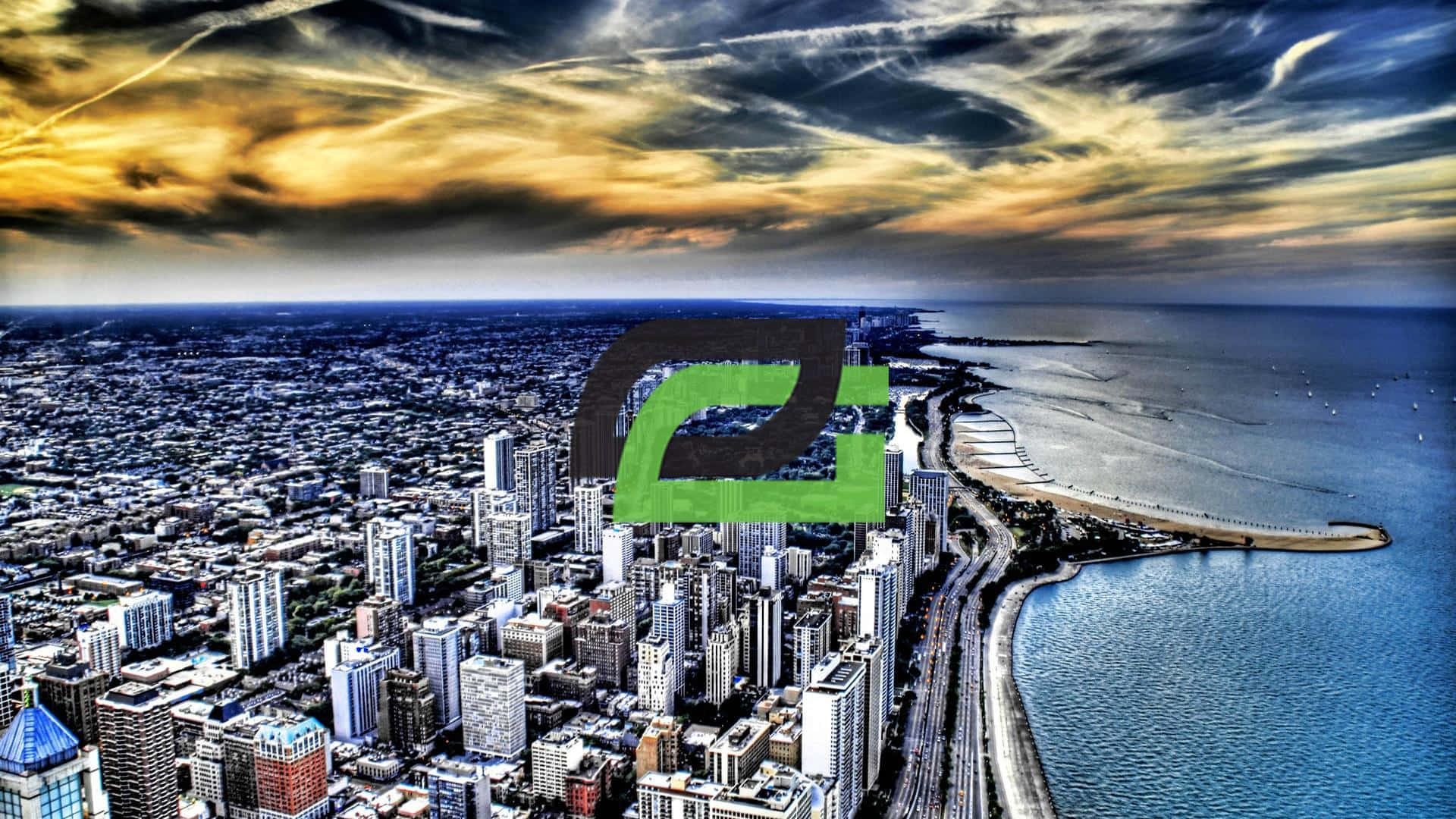Optic Gaming 桌布 壁紙 — 俯瞰一座擁有摩天大樓和彎曲海岸線的廣闊沿海城市，天空戲劇性地呈現金色和暗雲密佈。