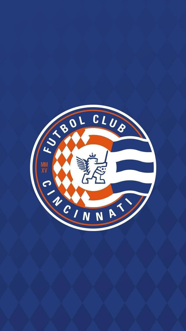 足球 桌布 壁紙 — Futbol Club Cincinnati 標誌居中於藍色菱形圖案背景上。