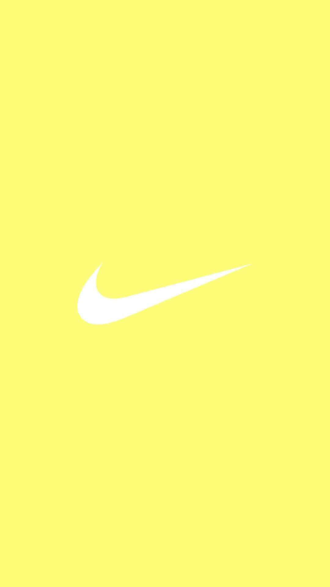Solid Yellow 桌布 壁紙 — 一個極簡白色Nike swoosh標誌，居中放在純亮黃色背景上。