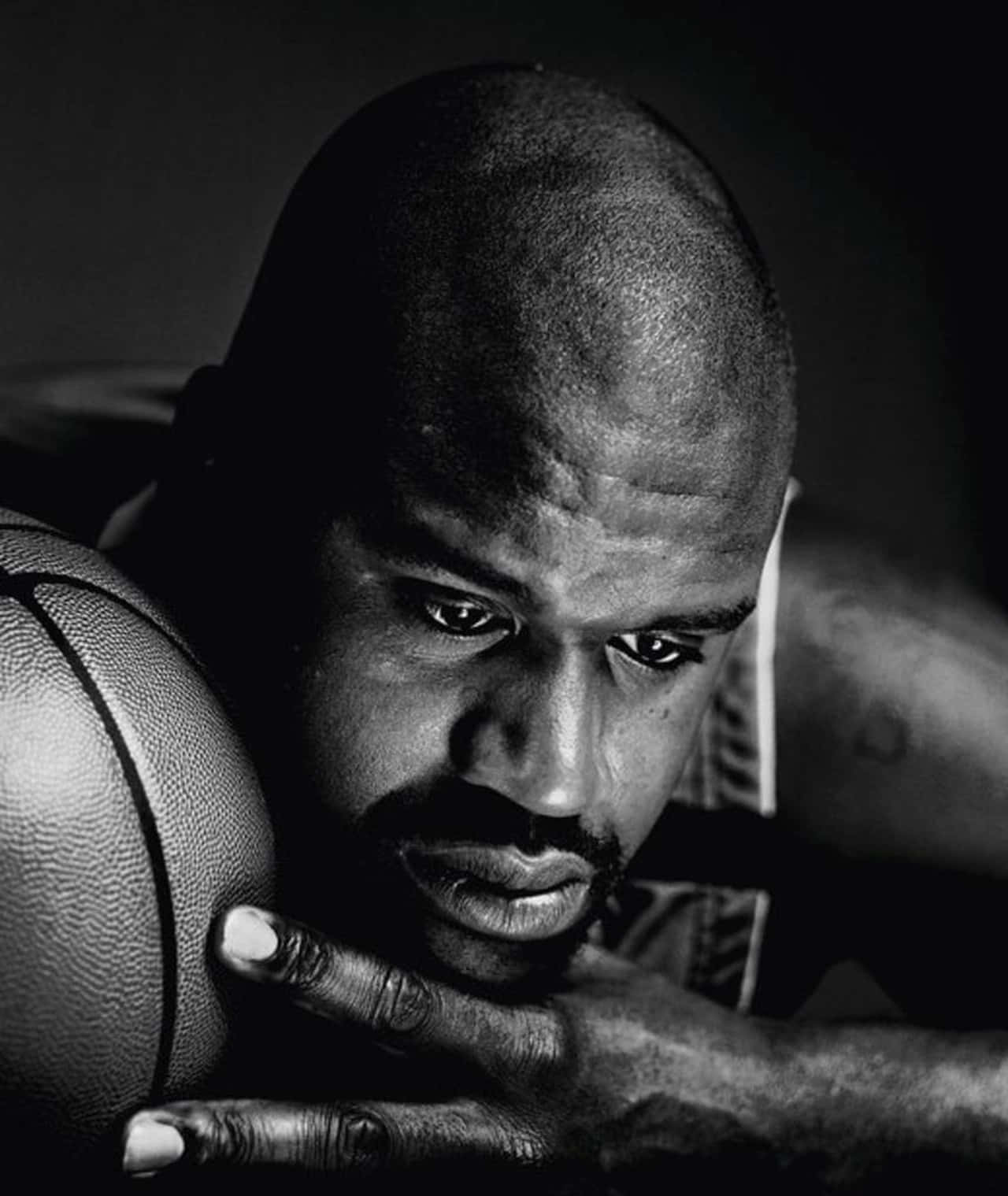 一位專注的籃球運動員在工作室肖像中持球。 — NBA 壁紙