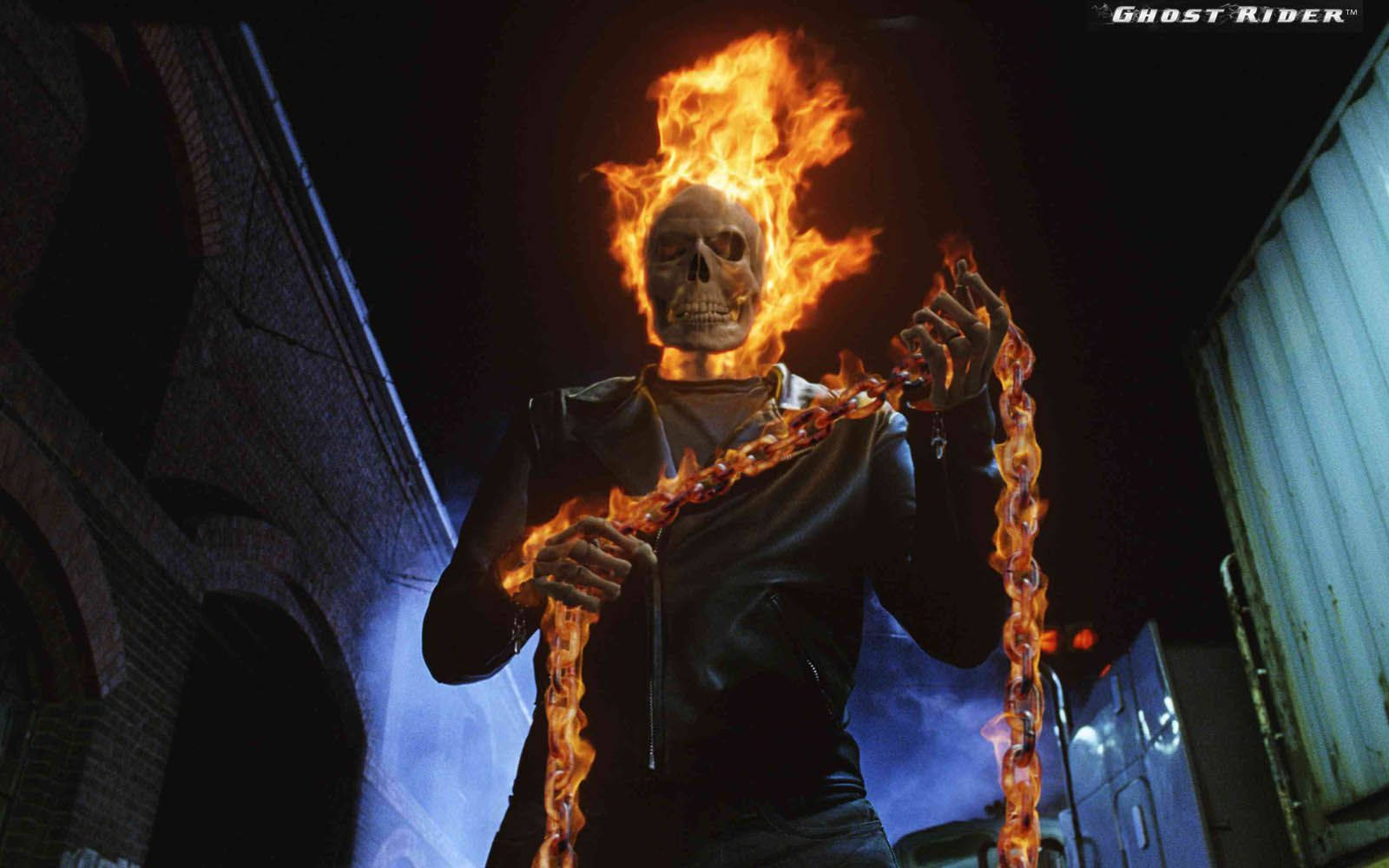 鬼 Rider 桌布 壁紙 — Ghost Rider 頭顱燃燒，手持鎖鏈，在夜晚黑暗的城市小巷中威嚇地站立。