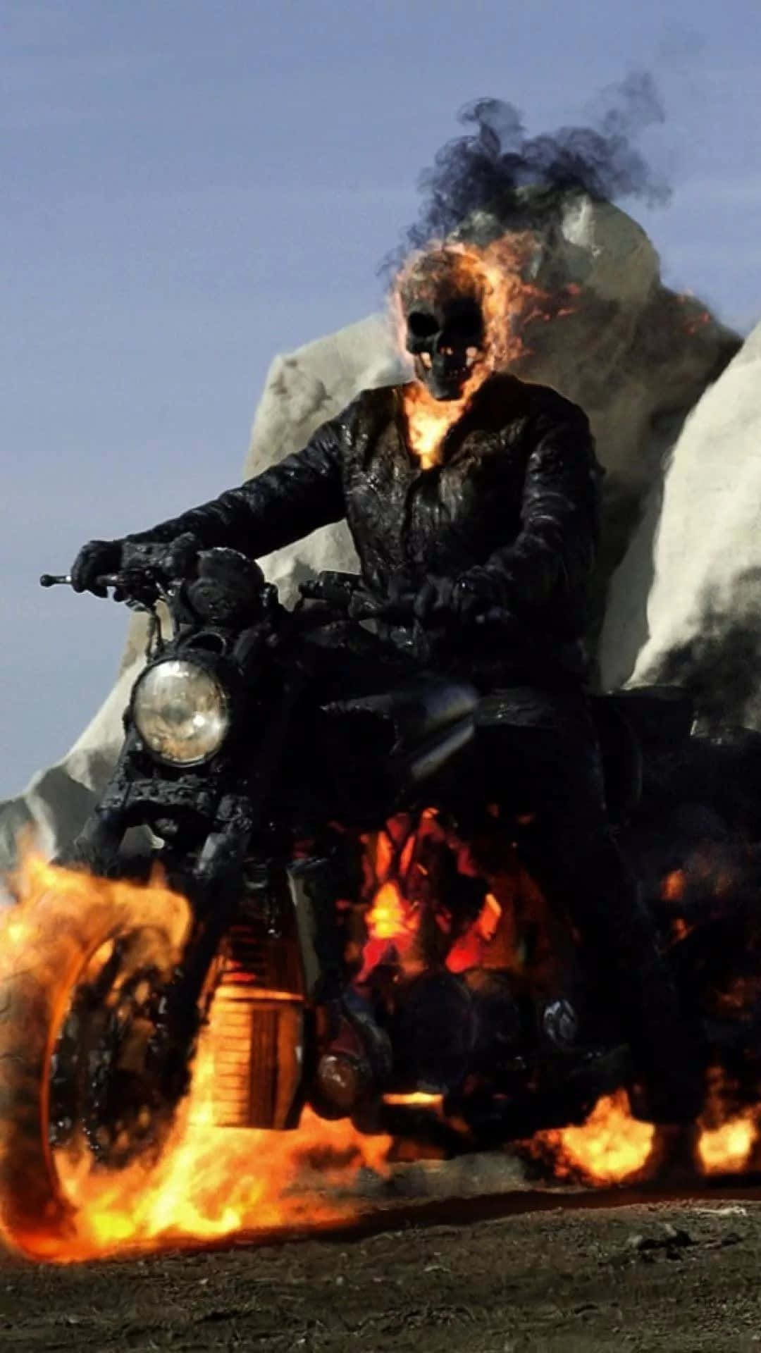  壁紙 — Ghost Rider 騎著一輛火焰摩托車穿過沙漠，身後升起煙霧。