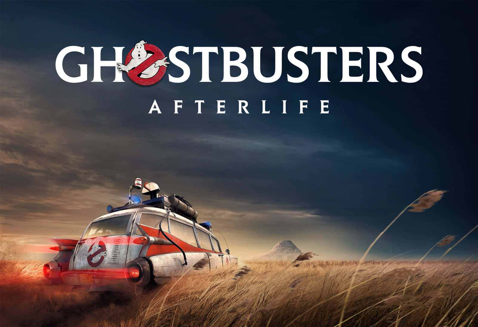 魔鬼剋星 桌布 壁紙 — Ghostbusters Ecto 1 在風暴暮色天空下行駛穿過金色草地，上方有電影標題。