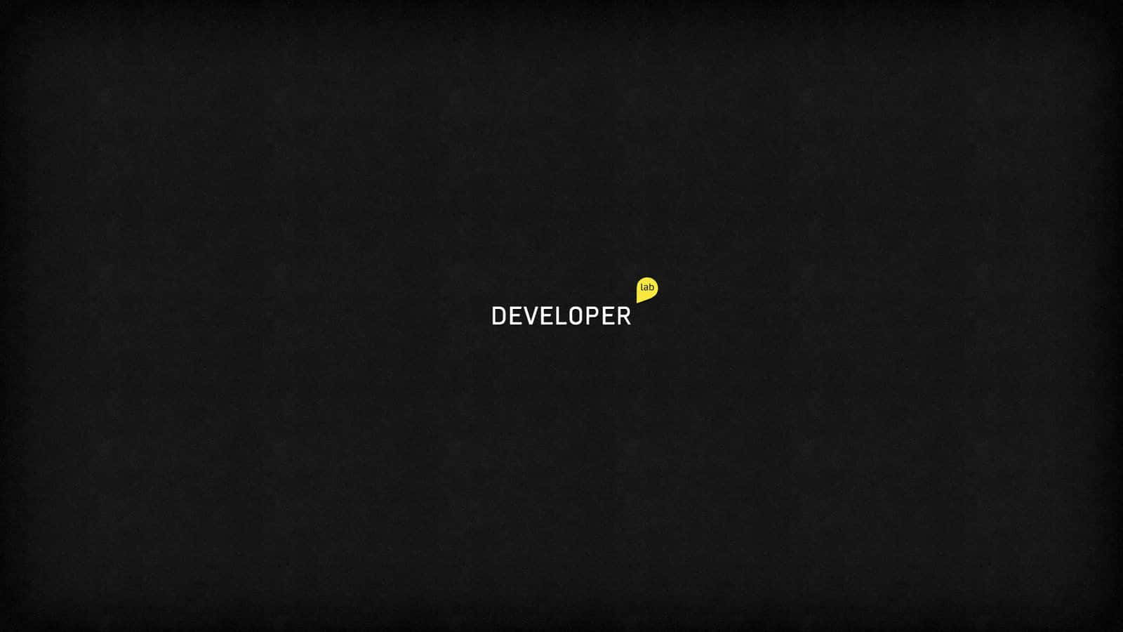 黑色紋理背景，白色文字 developer 和細小黃色對話氣泡。 — Macbook Pro 壁紙