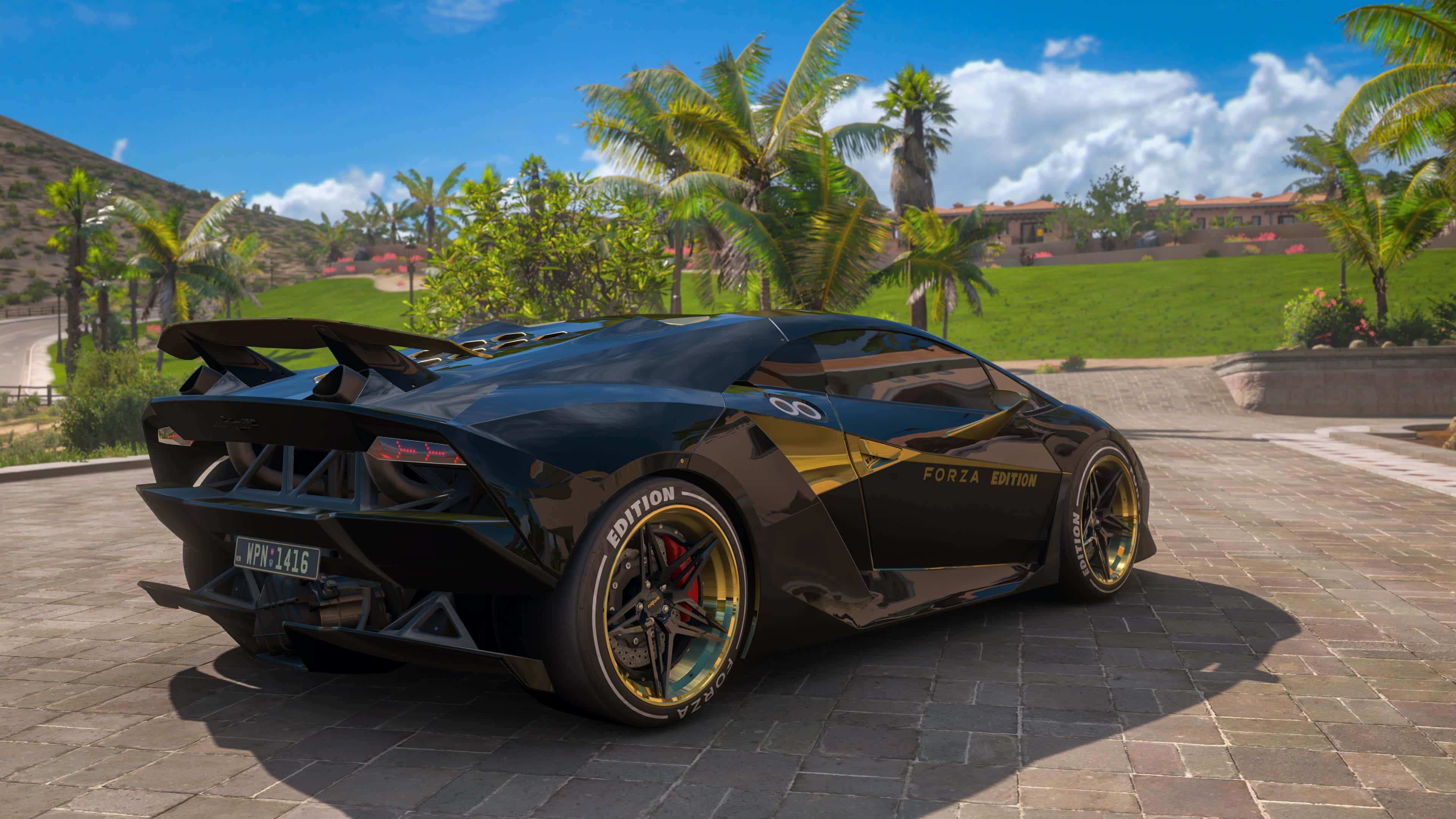 Lamborghini Sesto Elemento 桌布 壁紙 — 一輛帶有金色裝飾和Forza Edition貼紙的亮黑色藍寶堅尼，停泊在石頭車道上，上方是藍天和棕櫚樹。