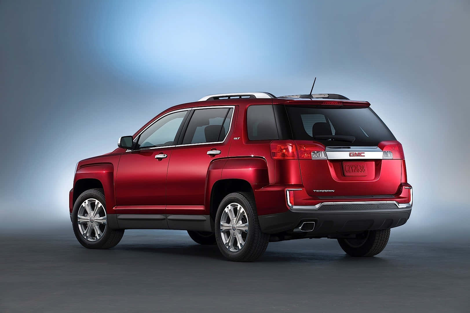 Gmc Terrain 桌布 壁紙 — 一輛亮紅色GMC Terrain SUV從後方四分之三角度展示，背景為漸變藍色攝影棚背景。