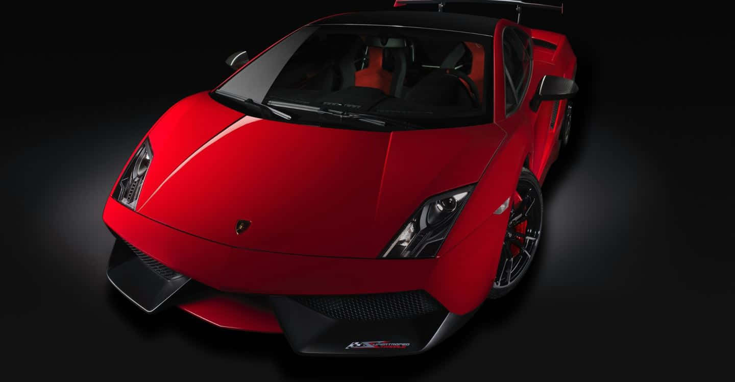 Lamborghini Gallardo 桌布 壁紙 — 一輛光澤的紅色藍寶堅尼Gallardo Superleggera跑車，帶有黑色飾邊和橙色內裝，在深色攝影棚背景下戲劇性地照明。