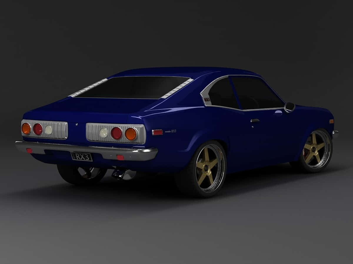 Mazda Rx-3 桌布 壁紙 — 一輛光澤的皇家藍色經典跑車，配備金色輪圈和鍍鉻裝飾，從後方四分之三角度展示，背景為深色工作室。