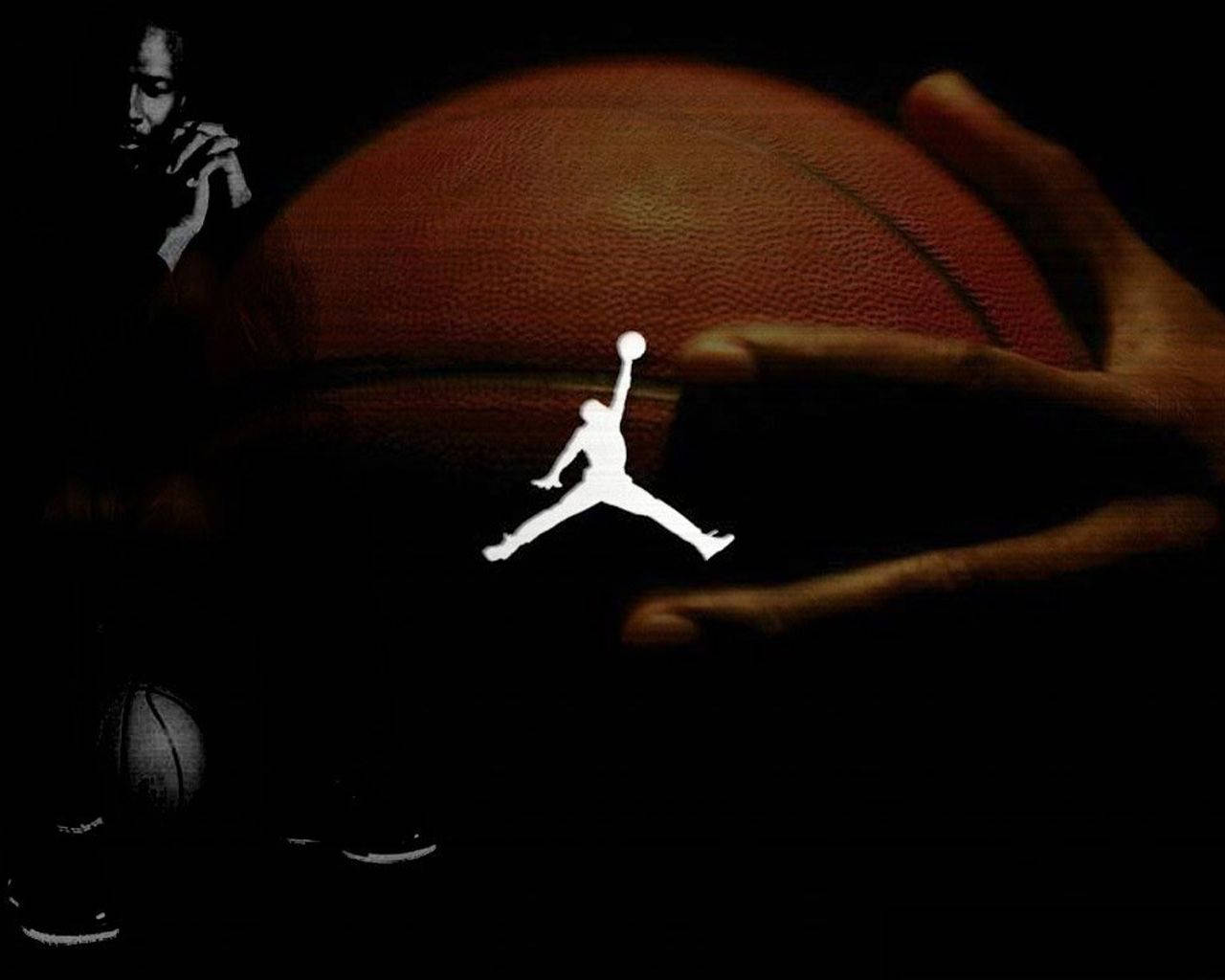 手捧籃球，帶有發光Jordan標誌和陰影Michael Jordan身影。 — Jordan Logo 壁紙