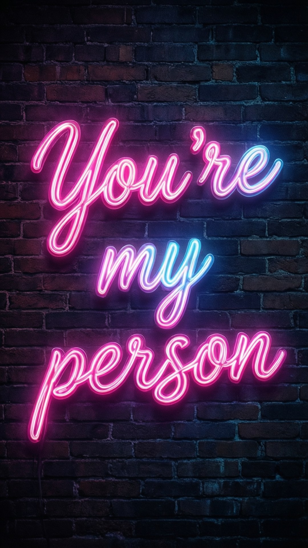 You're My Person Neon 壁紙 — 一個發光的霓虹燈牌，粉紅色和藍色字體寫著「You're my person」，背景是深色磚牆。