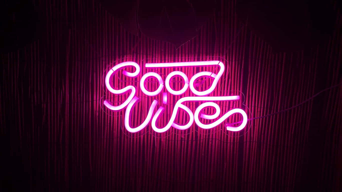  壁紙 — 一個發光的粉紅色霓虹燈牌，上面寫著「Good Vibes」，在深色竹簾背景下閃耀。