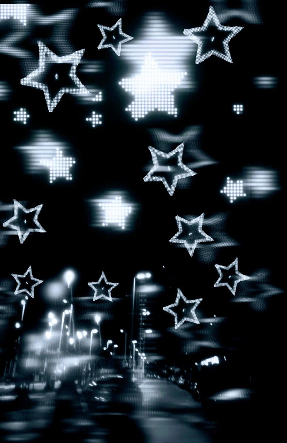  壁紙 — 發光的像素化星星漂浮在夜晚模糊的城市街道上方，帶有光條。
