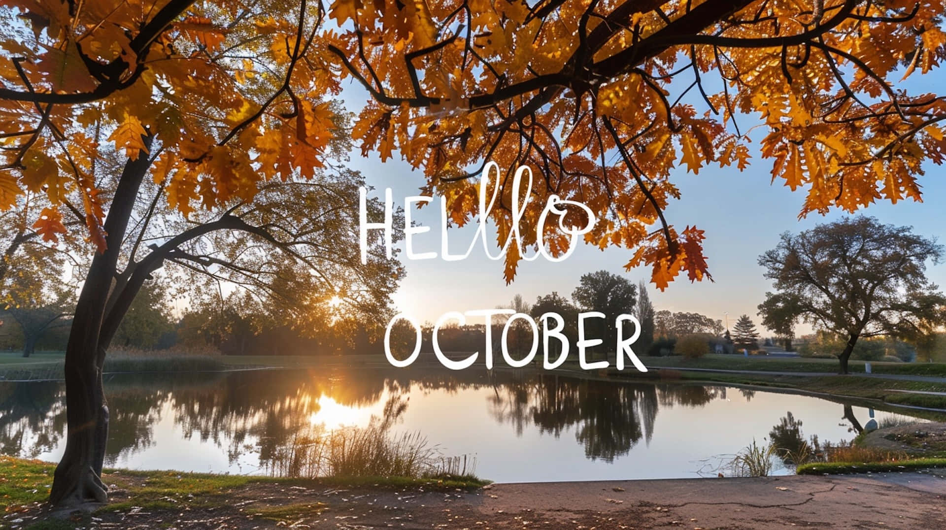 October Desktop 桌布 壁紙 — 金色秋葉框住寧靜湖泊，倒映溫暖日出，並帶有 'Hello October' 文字。