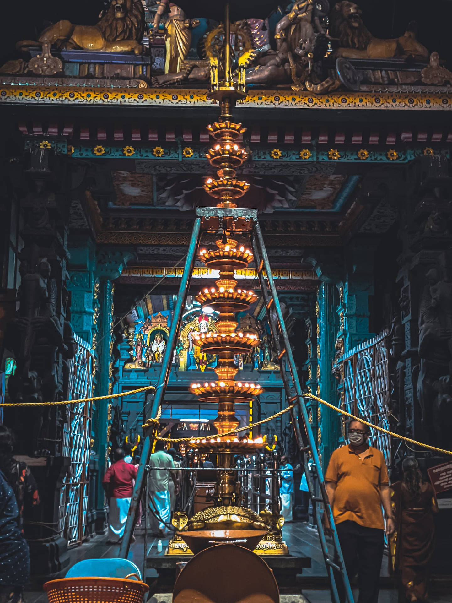 金色儀式燈在華麗的寺廟中，有朝拜者和藍色牆壁。 — 廟宇 壁紙