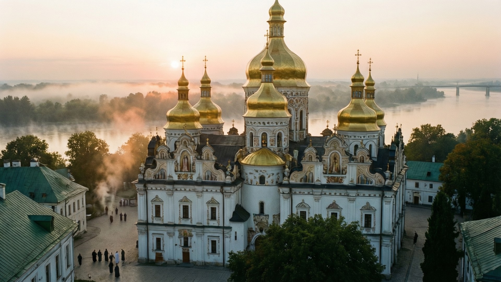 Pechersk Lavra Dawn 壁紙 — 一座宏偉白色大教堂的金色圓頂在日出時從霧氣瀰漫的河岸上升起，附近有人行走。