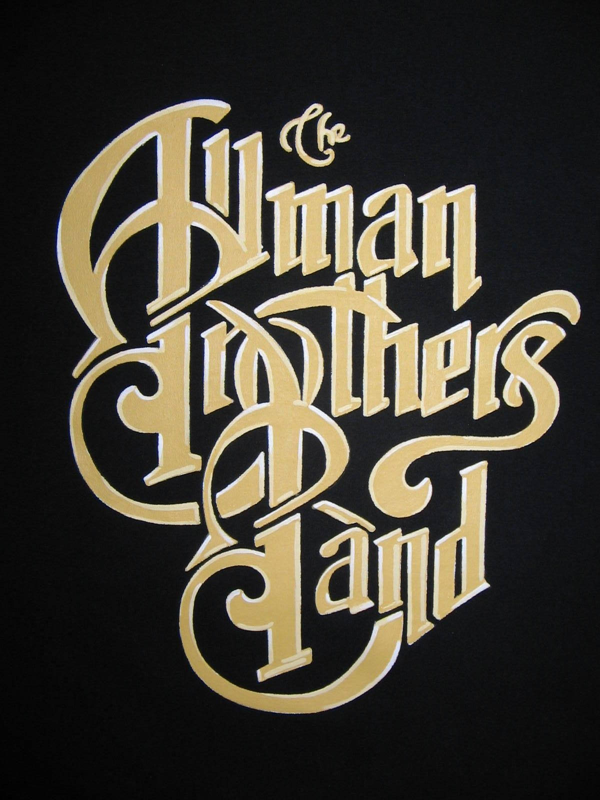 band 桌布 壁紙 — The Allman Brothers Band 的金色華麗字體在純黑色背景上發光。