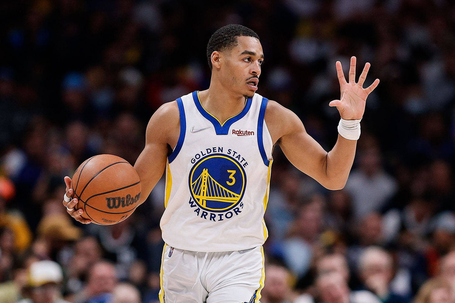 金州勇士籃球運動員在比賽期間運球，背景有觀眾。 — NBA 壁紙