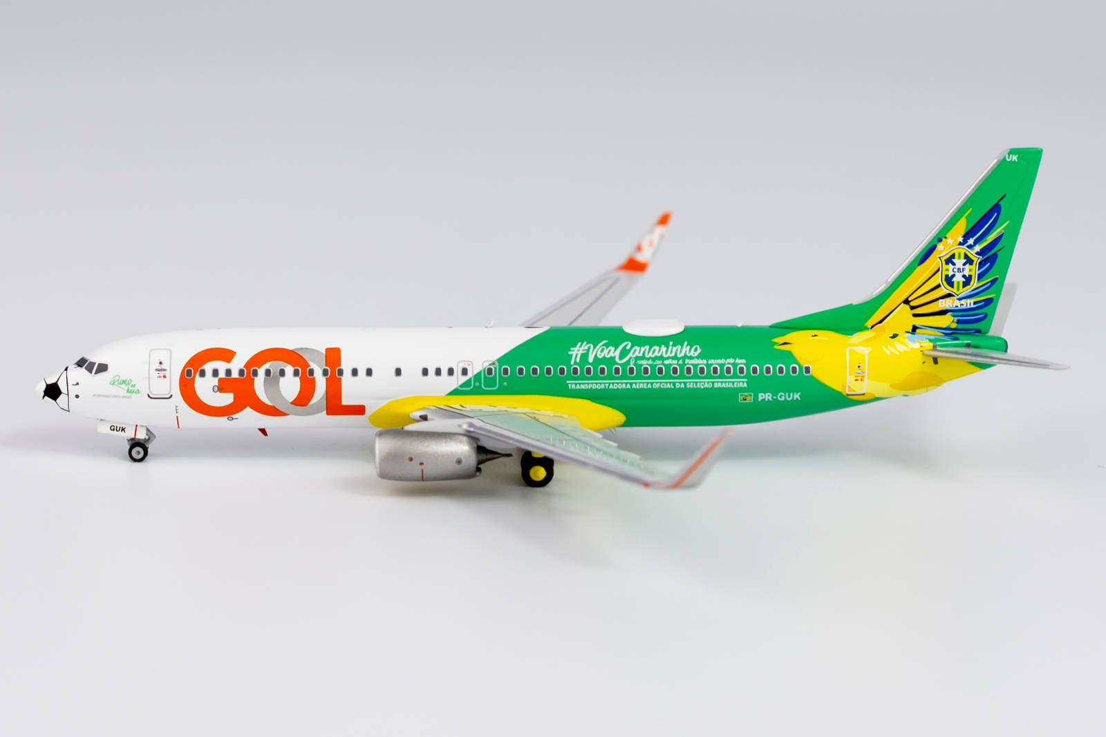  壁紙 — GOL航空公司波音737的詳細模型，帶有綠色、黃色和橙色塗裝，背景為純白色。
