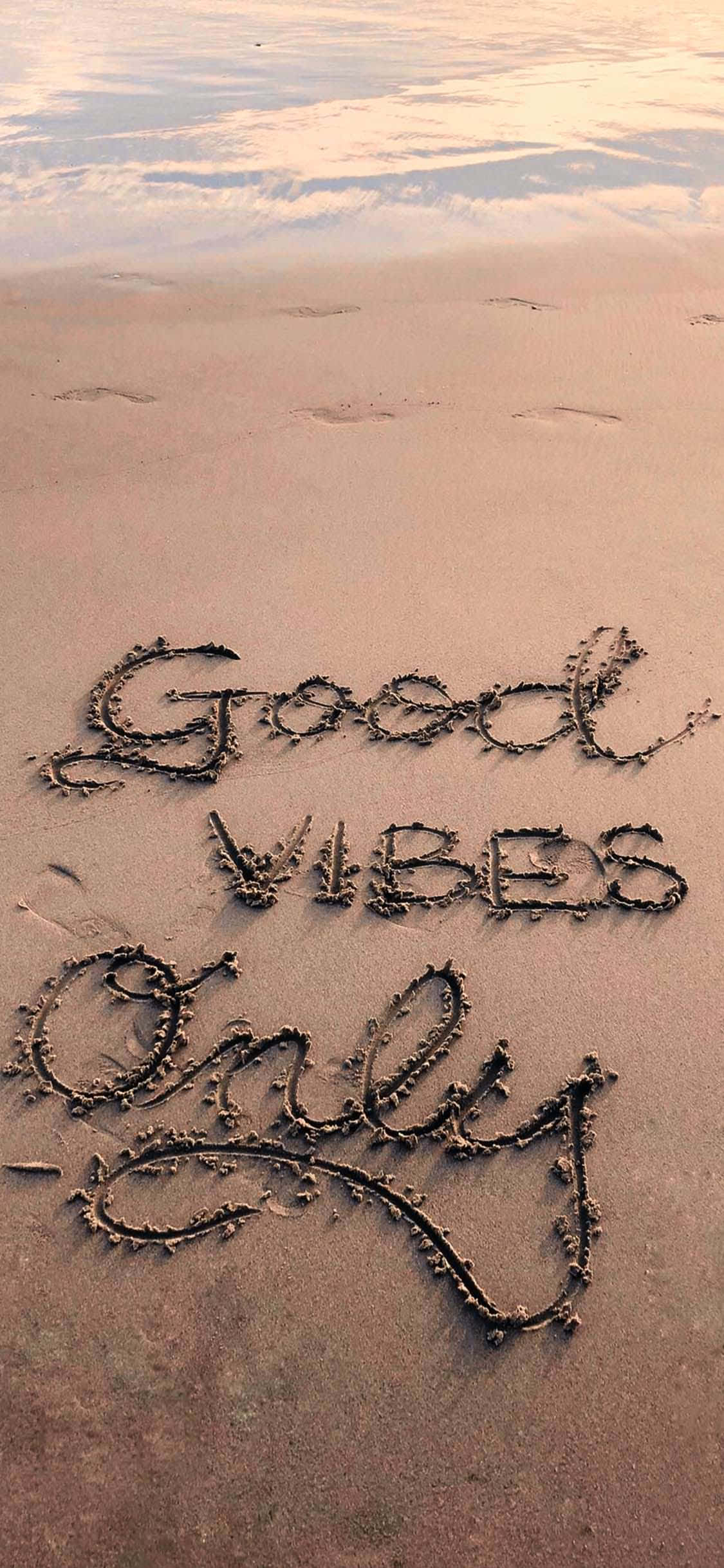 sand 桌布 壁紙 — 「Good Vibes Only」這句話用海藻在日落時的濕沙上以草書寫成。